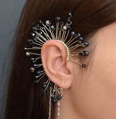 a close up of a woman's ear with black beads and chains attached to it