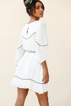 White tunic style dress  Partially lined  Three-quarter sleeves  Removable waist tie  Pom-pom trim detail  Non stretchy   Breeze through your day in our boho-chic Marionette dress. It's super versatile and we are loving the pom-pom trim detail. Perfect for lunch dates with your girls paired with ankle boots and a felt hat or dress it up with tan mules and some gold hoops for a chic look we are loving. Chic Summer Peasant Dress, Flowy Dresses With 3/4 Sleeves For Vacation, Chic Flowy Peasant Dress For Summer, Summer Boho Dress With 3/4 Sleeves For Beach, Summer Boho Beach Dress With 3/4 Sleeves, Summer Boho Dress For Beach With 3/4 Sleeves, Summer Beach Boho Dress With 3/4 Sleeves, Summer Boho Dress With 3/4 Sleeves For Vacation, Boho Dress With 3/4 Sleeves For Summer Vacation