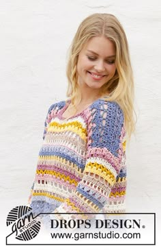 a woman wearing a multicolored crochet sweater and smiling at the camera