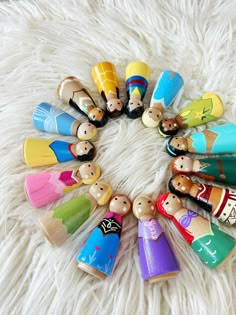 a group of wooden toy figures sitting on top of a white rug