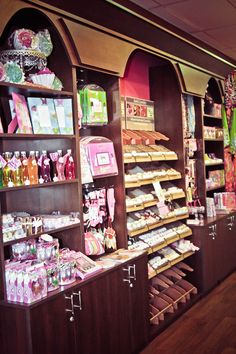 a store filled with lots of different types of candy and candies on wooden shelves