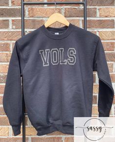 Vols Youth Sweatshirt  Vols Youth Shirt. Shirt is a unisex sweatshirt that is black with a black puff screen print design. The shirts are unisex shirts and are 100% preshrunk cotton.   All shirts are made to order and ship within a 2-3 days.  If you need a shirt sooner, please let me know and I will try my best to accommodate your request. Black Varsity T-shirt For Fall, Black Long Sleeve Sweatshirt For School Spirit, Black Varsity T-shirt With Screen Print, Black Sweatshirt For School Spirit Streetwear, Black Sweatshirt For Streetwear With School Spirit, Collegiate Black Crew Sweatshirt, Black Fan Apparel Sweatshirt For Fall, Black Collegiate Crew Sweatshirt, Black School Spirit Sweatshirt With Crew Neck