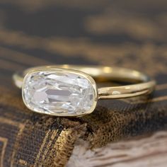 a close up of a ring on top of a book with a diamond in it