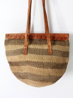 This is a woven sisal shoulder bag with leather top and accents. Warm hues of olive green and beige color the striped shopper. It closes with a belted leather strap, and long double straps carry the bag. It has an unlined interior. CONDITIONIn good condition with wear consistent with age and use. MEASUREMENTSWidth: 15" .. 38. 1 cmHeight: 9. 5" .. 24. 1 cmDepth: 9" .. 22. 9 cmStrap Drop: 15" .. 38. 1 cm62102 Handwoven Leather Bucket Bag, Handwoven Brown Leather Bucket Bag, Brown Leather Handwoven Bucket Bag, Leather Handwoven Tote Satchel, Handwoven Leather Shoulder Straw Bag, Handwoven Leather Straw Shoulder Bag, Brown Leather Straw Tote Bag, Brown Leather Tote Straw Bag, Leather Straw Basket Bag With Adjustable Strap