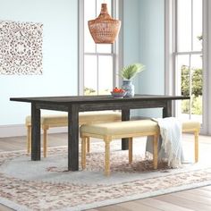 a dining room table with benches and chairs in front of large windows on a rug