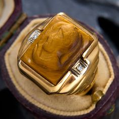 a gold ring with a tiger's eye stone in it