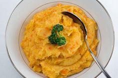 mashed potatoes and broccoli in a bowl with a spoon on the side