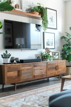 a flat screen tv mounted to the side of a wooden cabinet in a living room