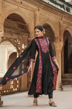 This exquisite Black Chanderi Silk Anarkali Suit Set features intricate Kashmiri embroidery, detailed with sequins and beads, and is lined with cotton voile. Completing the look is a solid chanderi silk slip-on trousers and a chanderi silk embroidered dupatta with scalloped edges. Color: Black Top: Chanderi Silk Bottom: Chanderi Silk Dupatta: Chanderi Silk Top Length: 48" Sleeves Length:17" Bottom Length: 38" Lining: Cotton Voile Occasion: Festive Print-Pattern: Paisley Ornamentation: Thread Wor Chanderi Anarkali Set With Embroidered Border, Floor-length Chanderi Churidar With Embroidered Border, Anarkali Kurta With Embroidered Border, Floor-length Embroidered Chanderi Churidar, Floor-length Embroidered Churidar For Diwali, Navratri Anarkali Embroidered Churidar, Navratri Anarkali Churidar With Embroidery, Unstitched Anarkali Set With Embroidered Border, Bollywood Style Floor-length Churidar With Embroidered Border