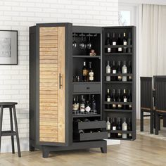 an open cabinet with wine bottles in it and two stools next to the door