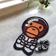 a pair of shoes sitting on the floor next to a door mat with an image of a monkey wearing a santa hat