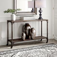 a console table with three vases and a mirror