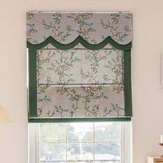 a window with a flowered valance hanging over it's windowsill in front of a white wall