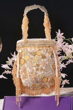 White velvet potli with floral, beads, crystal, dabka and swarovski hand embroidery. Comes with a detachable handle. - Aza Fashions Hand Embellished Pouch Bag For Reception, Hand Embellished Potli Bag For Festivals, Hand Embellished Potli Bag For Festival Celebrations, Luxury Hand Embellished Festive Bag, Luxury Hand Embellished Potli Bag For Reception, Embellished Potli Bag For Festivals And Celebrations, Luxury Potli Bag With Pearl Embroidery, Luxury Potli Bag For Reception, Luxury Embroidered Festive Bags