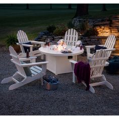 an outdoor table and chairs set up in gravel area with lit candles on the table