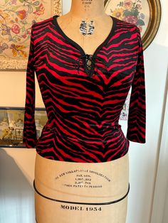 New old stock 90s funky top. Ties at chest. Tag says M but I'd say this would fit a modern 4/6.  Measurements taken with top lying flat: 16.5 inches pit to pit 12 inches across waist  20 inches top to bottom Passing through my smoke free, cat friendly home. Retro V-neck Stretch Top, Stretch 90s Tops For Fall, Stretch 90s Style Tops For Fall, Stretch Tops For Fall In 90s Style, Red Non-stretch Top For Fall, Fitted 90s Tops For Fall, Y2k V-neck Tops For Night Out, Fitted Graphic Print Blouse For Fall, Fitted Striped Y2k Top