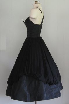 APPROXIMATE MEASUREMENTS (INCHES): Current Size: XS/S Tag size: 10 (please note this is vintage sizing; see measurements for more accurate current size/fit) Bust: 34 Waist: 25 Hip: OPEN Bodice (shoulder to waist): 17 Skirt (waist to hem): 32 CONDITION Excellent DESCRIPTION 1950s party dress Black taffeta and black chiffon fabric Fitted bodice and full skirt Back metal zip closure No manufacturer's label Fitted Evening Gown With Full Skirt, Fitted Gown With Full Skirt For Evening, Vintage Events Boned Bodice Ball Gown, Vintage Ball Gown With Boned Bodice For Events, Ball Gown With Boned Bodice For Vintage Events, 1950s Fitted Prom Dresses, Vintage Evening Dress With Boned Bodice, Vintage Ball Gown Dresses For Vintage Events, Vintage Ball Gown Dress With Lined Bodice