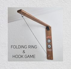 a piece of wood hanging from the side of a wall next to a clock on a hook