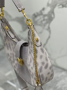 With its unique shape, iconic details and versatile charm, it adds a fashionable atmosphere to the world of SERPENTI FOREVER.
This everyday bag is crafted from silver-pink calfskin with a cowhide center and snake-print blue scales on both sides. It is paired with gold-plated brass accessories. The charming classic snake head is embellished with silver scales and pink enamel eyes in the center. The front magnetic buckle is hidden Under it.
Featuring a single compartment, adjustable chain and leather shoulder strap and removable leather handle, it can be worn cross-body or as a classic shoulder bag. Practical top zip with an internal pocket, an external pocket on the back and BVLGARI metal logo.

Dimensions: 25.5×25×5.5 cm High-end Silver Shoulder Bag With Palladium Hardware, High-end Silver Shoulder Bag, Luxury Silver Shoulder Bag For Travel, Luxury Silver Shoulder Bag With Gold-tone Hardware, High-end Silver Leather Shoulder Bag, Luxury Silver Bag With Chain Strap, Luxury Silver Bags With Chain Strap, Elegant Silver Shoulder Bag With Textured Leather, Silver Luxury Shoulder Bag For Everyday