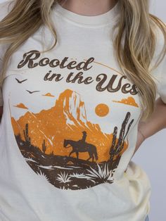 Ride into style with this wild west tee. Crafted from soft ring-spun cotton, this tee ensures comfort without compromising on durability. With a bold western graphic, it captures the essence of rugged, frontier spirit. Perfect for everyday wear, this heavyweight tee blends timeless comfort with iconic western flair, making it a standout piece in any wardrobe. Soft Ring, Guinea Bissau, Wild West, Dress First, Spun Cotton, Everyday Wear, Essence, Top Outfits, Wardrobe