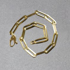 This simple yet dramatic bracelet combines the timeless shine of 14K yellow gold and the modern geometry of paperclip chain links. Bracelet is 7 1/2 inches long, 4.2mm wide, and closes with a lobster clasp.Product Details: Bracelet Information : Metal : 14K Yellow Gold Chain Type : Link Clasp : Lobster Clasp Width : 0.17 in Approximate Weight: Size Weight 7.5'' 2.5 grams Everyday Gold-tone Paperclip Bracelet With Rectangular Links, Gold-tone Paperclip Bracelet For Everyday, Modern Gold-tone Paperclip Bracelet, Gold-tone Link Paperclip Bracelet With Lobster Clasp, Minimalist Gold-tone Paperclip Bracelet With Solid Links, Modern Gold-tone Link Bracelets, Modern Paperclip Chain Jewelry, Modern Gold Bracelet With Box Chain, Modern Rectangular Gold Bracelet With Box Chain