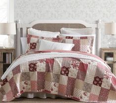 a bed with a red and white quilt on it's headboard next to two nightstands