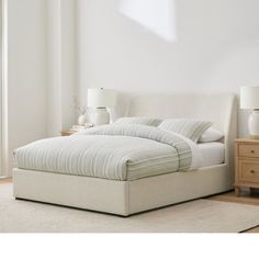 a white bed sitting in a bedroom on top of a wooden floor