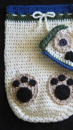 a crocheted bag with eyes and paws on it