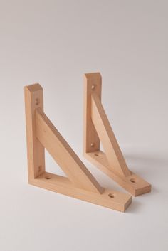 two pieces of wood sitting next to each other on a white surface with one piece missing