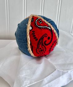 a red and blue ball sitting on top of a white sheet