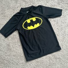 Nwot Batman Wash Guard Shirt. Size Large. Never Worn And In New Condition. My Kids Outgrew It Before They Had A Chance To Wear It. My Loss Is Your Gain! Short Sleeves And A Little Collar. Will Ship Quickly Smoke And Pet Free Home Playful Black Fitted Tops, Playful Fitted Black Tops, Yellow Fitted School Top, Yellow Fitted Tops For School, Black Crew Neck Tops For Playwear, Black Short Sleeve Tops For Playwear, Black Long Sleeve Tops For Playwear, Black Character Print Top For School, Fitted Character Print Tops For Playwear