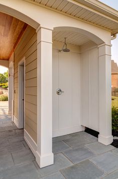 an outside view of a house with a white door and brown trim on the side