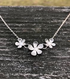 Beautiful, elegant, and whimsical. This silver flower necklace is sure to be a hit! Three darling flowers dance on a delicate yet strong fine silver chain in a length of your choice and secured with a silver lobster clasp. The flowers measure 2 inches across and 7/8 inch tall in the middle. Delicate Silver Jewelry With Flower Decoration, Delicate Sterling Silver Petal Jewelry, Silver Flower Jewelry With Handmade Flowers, Silver Flower Necklace For Anniversary, Silver Flower Necklace For Wedding, Sterling Silver Jewelry With 3d Flower Design, Handmade Flower-shaped Silver Jewelry, Whimsical White Flower Necklace, Silver Delicate Flower Charm Necklace