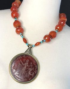 Vintage Afghan Pendant Necklace This One of a Kind Statement Necklace is assembled by me. I collected this incredible genuine Carnelian Intaglio pendant on my recent travels. The pendant is encased in brass with a silver rope design and lovely ornate metal backside of the pendant.  This style of carved Carnelian is associated with Bactria, once part of the Persian Empire. Carnelian has always been considered a lucky talisman throughout ancient history and is still popular today. Red Carnelian is Antique Orange Gemstone Jewelry, Red Carnelian Vintage Jewelry, Vintage Red Carnelian Jewelry, Antique Carnelian Necklace For Gift, Antique Style Necklaces With Natural Stones, Antique Gemstone Beaded Jewelry, Handmade Vintage Carnelian Beaded Necklace, Antique Round Gemstone Beads Jewelry, Artisan Carnelian Jewelry For Collectors