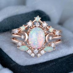 an opalite and diamond ring on top of a white furnishe blanket