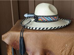 I fashioned this hat after being inspired by the intricate Native American Indian headdresses. This is a palm leaf Gus hat body . It has a 4" brim and a 5 1/4" crown. It is hand laced in black leather lace. The hatband has a base of black suede that is then decorated with two rows of nailspots and finished with this incredibly colorful beaded hatband. Black tassels for that extra accent. And check out the Harris Hawk feather which is actually a turkey feather that has been trimmed and hand paint Adjustable High Crown Sun Hat For Vacation, Natural Toquilla Straw Hat With High Crown, Adjustable High Crown Sun Hat For The Beach, Adjustable High Crown Sun Hat For Beach, Adjustable High Crown Toquilla Straw Panama Hat, Adjustable High Crown Straw Hat For Beach, Adjustable High Crown Straw Hat In Natural Color, Adjustable Bohemian Palm Leaf Hat, Bohemian Natural Hat For Kentucky Derby