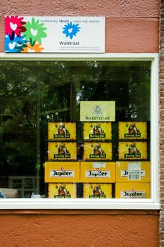 a man sitting in front of a window filled with boxes