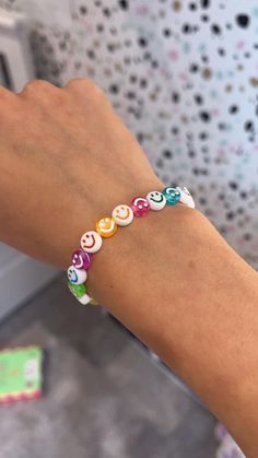 a woman's arm with a bracelet made out of colorful beads on the wrist