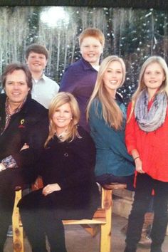 a group of people posing for a photo in front of a fountain with snow falling on the ground