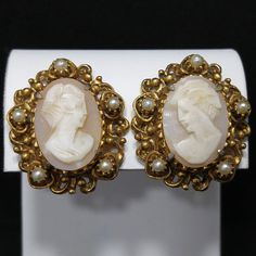 "*Description: This is a beautiful pair of Florenza carved shell earrings in a gold plated filigree frame with small faux pearl accents. The earrings are clip and are signed on the back side of each earring, FLORENZA, with the copyright symbol. These earring \"Ladies\" are each unique and it is obvious they are carved due to the unique features in their faces and the depth of each carving. Each unique cameo is set in gold plated filigree with five faux pearls on each earring. This would be a gre Victorian Pearl Earrings For Pierced Ears, Vintage Formal Pierced Pearl Earrings, Vintage Pierced Pearl Earrings For Formal Occasions, Vintage Earrings With Intricate Design For Formal Events, Vintage Earrings With Intricate Design For Formal Occasions, Vintage Yellow Gold Clip-on Pearl Earrings, Antique Clip-on Earrings For Anniversary, Victorian Gold Earrings For Vintage Events, Vintage Yellow Gold Pearl Earrings For Wedding