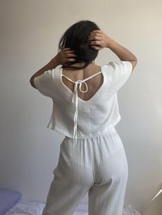 "Women's muslin pajamas made from 100% organic cotton. The handmade night set is the best gift for her. The set includes: straight-cut trousers and a T-shirt with a cut-out at the back with ties and a dropped shoulder. Experience the highest quality of our pajamas. Homewear is a unique type of product designed to give a feeling of comfort, coziness and warmth. The natural fabric is suitable for all temperatures, providing the breathability your skin needs. This is an indispensable thing in your wardrobe, which for many years will delight you with a consistently stunning appearance. The design is cute and fits most body types, making you feel and look amazing. Our advantages: - Unique design;  -Sustainable Fabrics: I only use sustainable fabrics to create our pajamas, making them safe for h White Cotton V-neck Sleepwear, White V-neck Bedtime Set, Summer Cotton Sleepwear Matching Set, White Cotton Sleepwear For Summer, Cotton Matching Set Tops For Pajama Party, Cotton V-neck Relax Fit Sets, White Relaxed Fit Matching Sleepwear Set, Relaxed Fit Cotton V-neck Sets, Organic Cotton Sleepwear For Spring