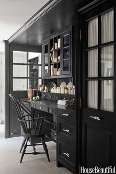 a black and white home office with lots of cabinet space, including an open desk