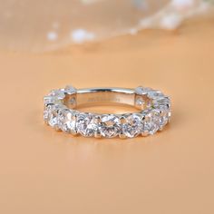 Celebrate your everlasting love story with this elegant band. Stunning as a wedding or anniversary band, it showcases a row of sparkling round stones across the center. With grace and shimmer, this sparkling band is a classic style that complements her sophisticated taste. Carat Weight: 4.125 ctStone Size: 4 mmStone Type: Jeulia® StoneNumber of Stones: 15 Stone Color: Diamond WhiteStone Shape: RoundWeight: 4.38 gWidth: 4.03 mmHeight: 3.92 mmThickness: 2.33 mmMaterial: 925 SilverPlating Color: Si Lab Grown Diamond Eternity Band For Anniversary, Cubic Zirconia Eternity Band With Prong Setting For Anniversary, Anniversary Eternity Band With Prong Setting In Cubic Zirconia, Anniversary Eternity Band Vvs Clarity, Vvs Clarity Lab Grown Diamond Eternity Band For Anniversary, Promise Ring Eternity Band With Prong Set Moissanite, Diamond White Moissanite Eternity Band For Anniversary, Moissanite Eternity Band With Prong Setting For Promise Ring, Diamond White Lab Grown Diamond Eternity Band For Anniversary