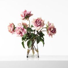 a vase filled with pink flowers on top of a table