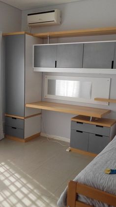 a bedroom with a bed, desk and shelves