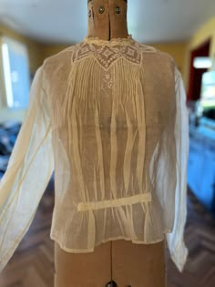 "A sweet Edwardian blouse in beautiful condition.  Made of a creamy silk organdy with tiny floral pattern, the blouse has gathers at the front waist, and filet lace and pintucks at the neckline.  There is a small flower embroidered at the centre front. Press studs at the rear, full sleeves and matching filet lace at the cuff. In excellent condition  Size medium.  Bust 36\" Waist 36\" Length 19\" Sleeve length 23\"" Sheer Blouse For Daywear, Sheer Fitted Blouse For Daywear, Fitted Sheer Blouse For Daywear, Vintage Collar Blouse For Wedding, Elegant Long Sleeve Blouse With Yoke Detail, Beige Lace Collar Blouse For Daywear, Feminine Sheer Blouse For Daywear, Feminine Lace Work Blouse For Daywear, Cream Blouse With Lace Collar For Daywear