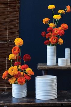 three white vases with colorful flowers in them