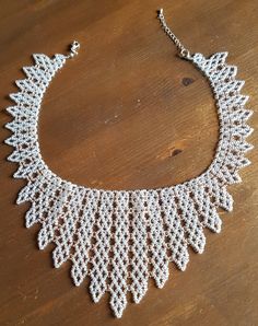 a white beaded necklace on a wooden table