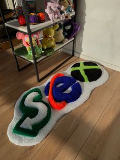 there are many stuffed animals on the floor in front of a book shelf with books