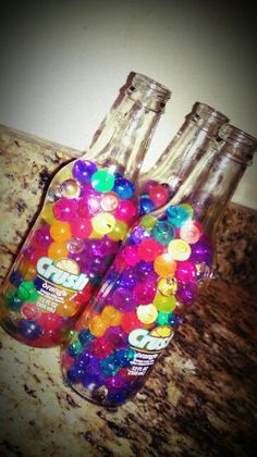 two bottles filled with gummy bears sitting on top of a counter